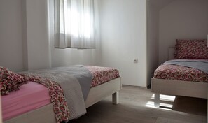A bedroom with two beds, one with a floral bedspread and the other with a plain one. - Apartment Meryl (ST) - Two Bedroom Apartment with Sea View (Mravince)