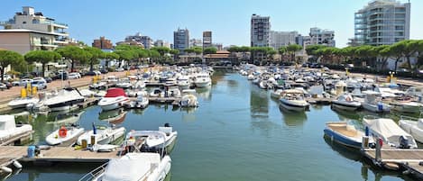 A marina with numerous boats docked, surrounded by buildings and trees.