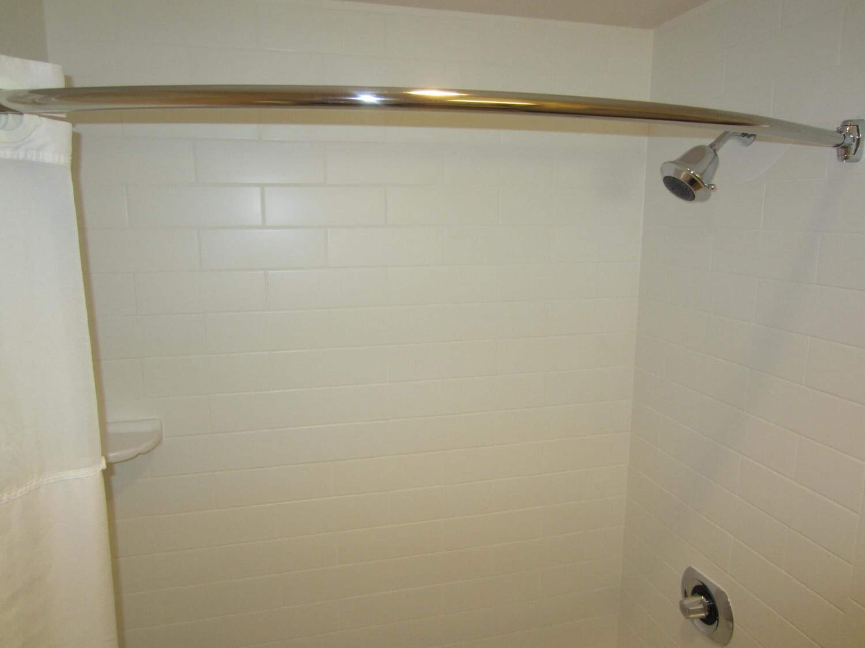 A shower with a glass door and a handheld showerhead.