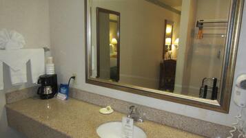 A bathroom with a sink, mirror, and towel rack.