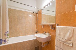 Bathtub, hair dryer, towels, shampoo