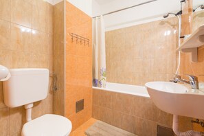 Een bad, een haardroger, handdoeken, shampoo