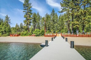 A wooden dock leading to a clear water body, surrounded by dense forest and a clear sky. - Lake Tahoe’s Ultimate Family & Friends Retreat (Olympic Valley)