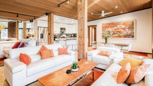 A modern living room with white sofas, orange cushions, and a wooden coffee table. - Lake Tahoe’s Ultimate Family & Friends Retreat (Olympic Valley)
