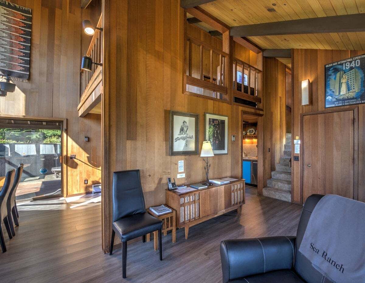 A spacious lobby with a wooden interior, a staircase, and a view of the outdoors.