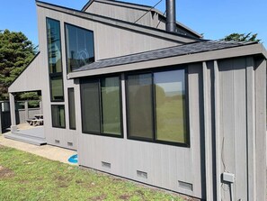 A modern two-story house with large windows and a covered patio area. - Quail View - Spacious Sea Ranch Family Lodge (Sea Ranch)