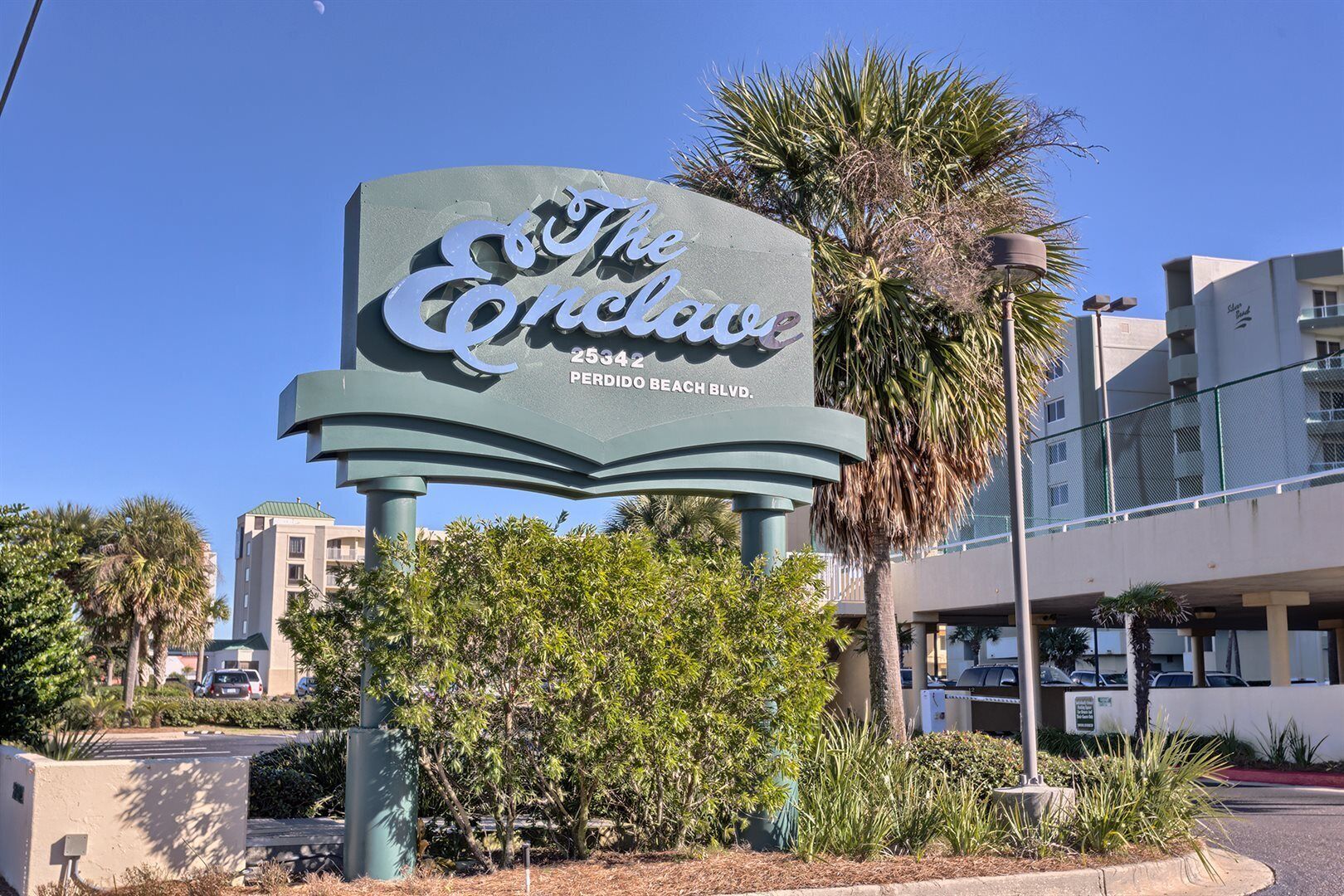 A hotel sign with the name 'The Conclave' and address '25342 Perdido Beach Blvd.'