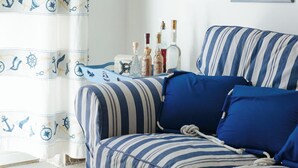A room with striped bedding, a straw hat on the wall, and framed pictures. - Seaside house - Casazzurra, Sicily (Sampieri)