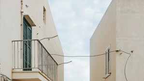 A narrow cobblestone street flanked by buildings with balconies overlooking a body of water. - Seaside house - Casazzurra, Sicily (Sampieri)