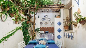 A narrow outdoor dining area with a blue tablecloth, white chairs, and blue plates. - Seaside house - Casazzurra, Sicily (Sampieri)