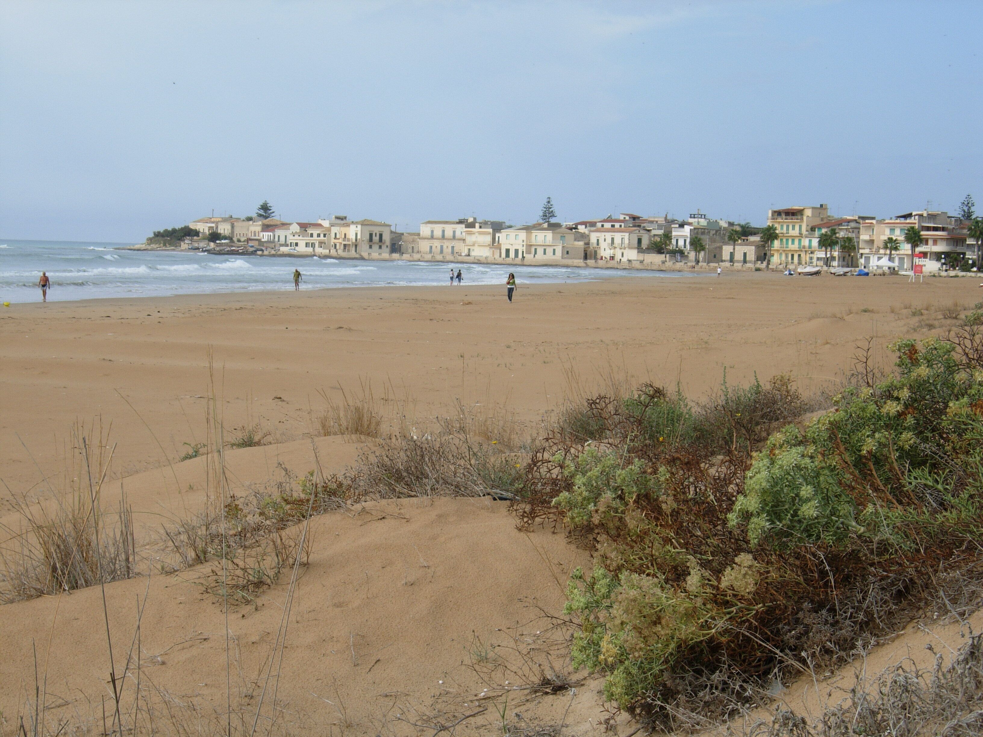 Une plage de sable avec des bâtiments en arrière-plan.