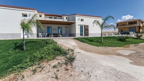 A modern two-story building with a covered patio and outdoor seating area. - Nice home in Ragusa with private swimming pool, can be inside or outside (Ragusa)