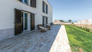 A modern building with a paved patio, outdoor seating, and a view of the sea. - Nice home in Ragusa with private swimming pool, can be inside or outside (Ragusa)