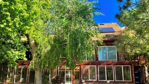 A two-story building with large windows, a stone facade, and a red roof. - Prescott Paradise! Sunroom Suite in the Heart of the Granite Dells! (Prescott)