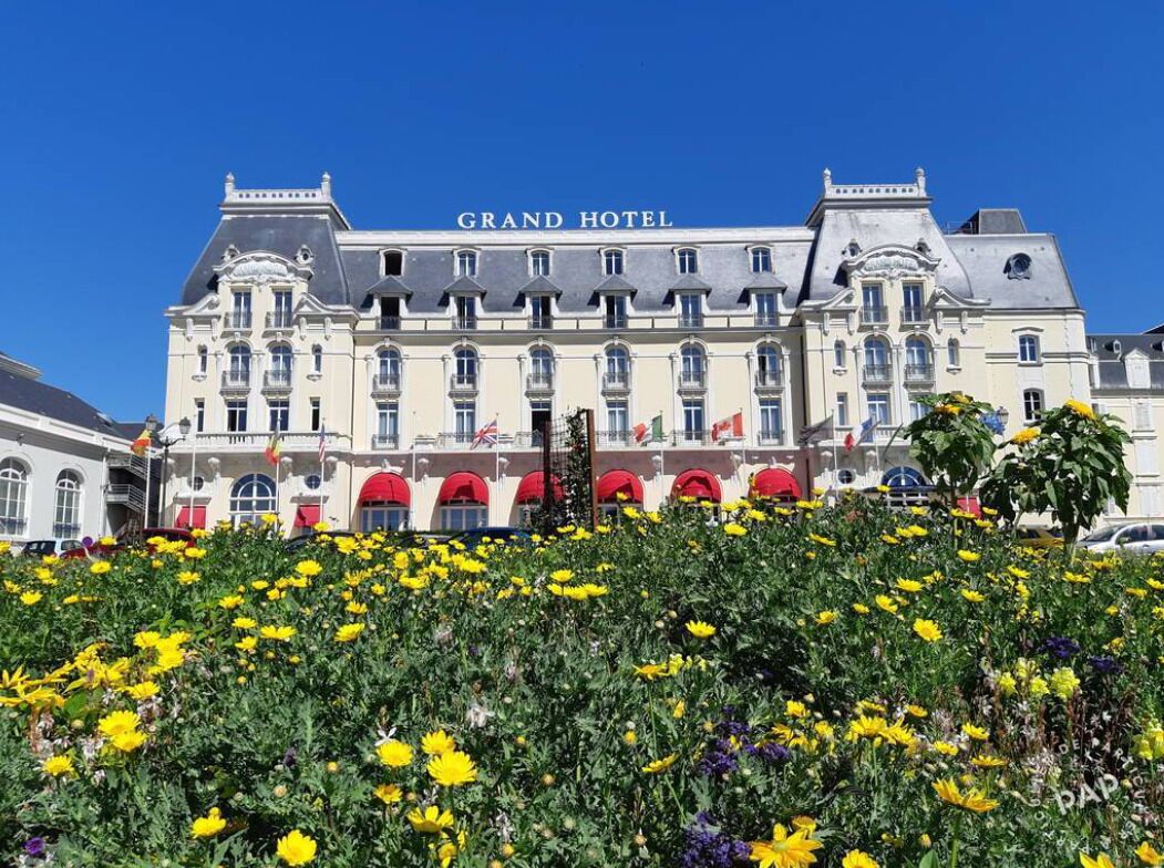 A grand hotel with a classic European architectural style, featuring multiple balconies and a prominent entrance.