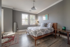 A bedroom with a wooden bed, a nightstand, a lamp, and a window with blinds. - Centrally Located SOHO Retreat Walkable to UT & Dining (Tampa)