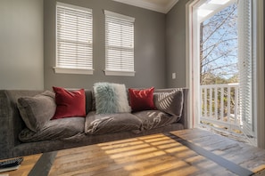 A grey-walled room with a grey sofa, red and white pillows, and a wooden coffee table. - Centrally Located SOHO Retreat Walkable to UT & Dining (Tampa)
