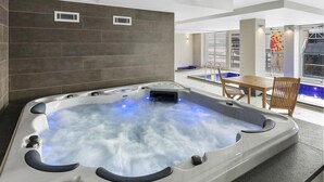 A modern indoor hot tub with a view of a pool and a dining area. - Swainson at Embassy - 917 (Adelaide)