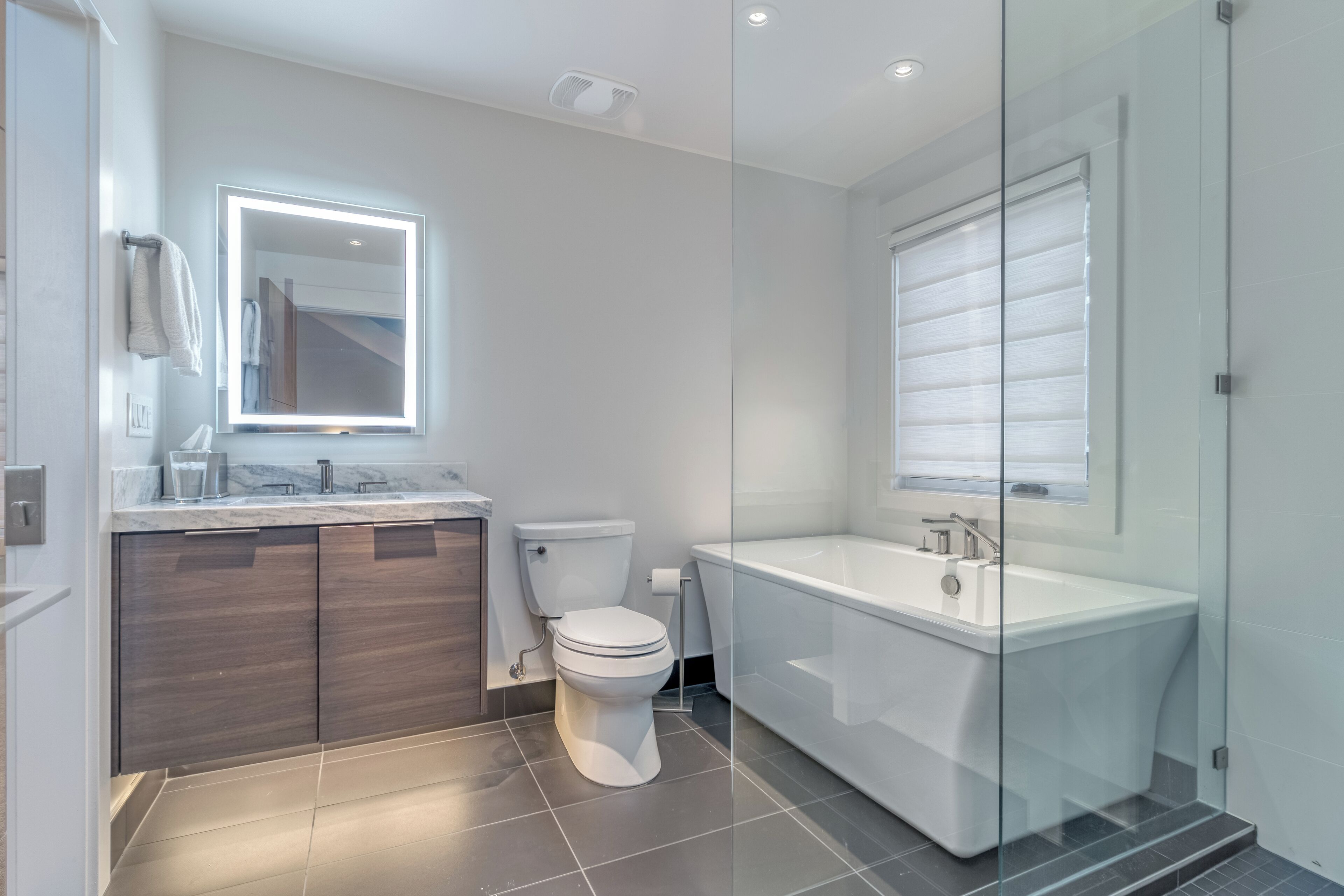 Un baño moderno con inodoro, tocador y bañera.