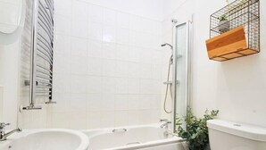 Un baño con bañera, lavamanos e inodoro.