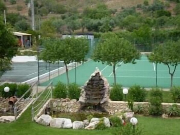 Enjoy a peaceful retreat amidst lush greenery and a tennis court.