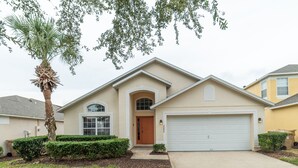 A single-story house with a garage, a front door, and a palm tree. - ✨ Great Value 3BR Villa w/ Private Pool & Game Room near Disney 🏝️🎢 (Kissimmee)