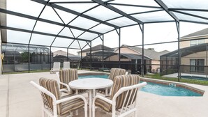 An outdoor patio area with a pool, covered seating, and a view of neighboring houses. - ✨ Great Value 3BR Villa w/ Private Pool & Game Room near Disney 🏝️🎢 (Kissimmee)