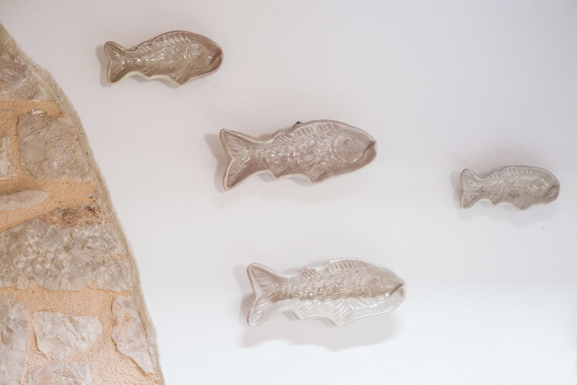 Eine Wand mit fünf fischförmigen Verzierungen.