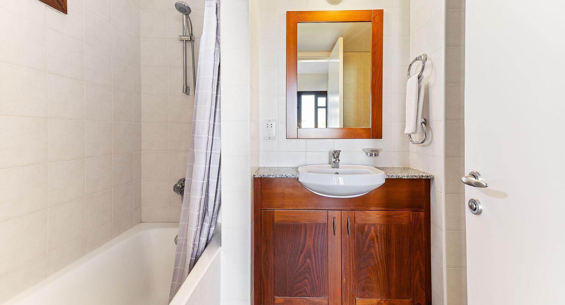 Un baño con bañera, lavamanos y espejo.