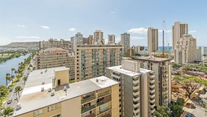 A high-rise hotel with multiple balconies, a river view, and a construction crane in the background. - Waikiki Moana Inn (Honolulu)