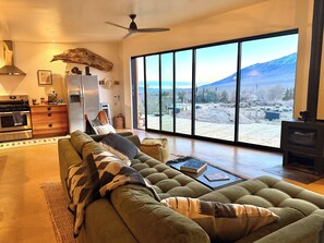 A spacious living room with a large sofa, a dining area, and a kitchen.