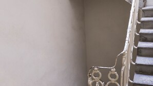 Eine Treppe mit Metallgeländer und einer Betonwand.