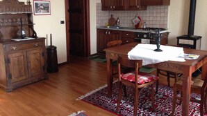 Una cocina con armarios de madera, una estufa y una chimenea negra.