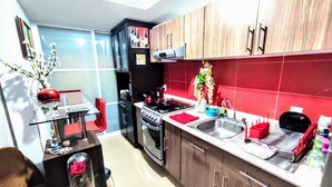 A modern kitchen with a gas stove, sink, and wooden cabinets. - Complete Apartment in Coapa CDMX (Ciudad de México)