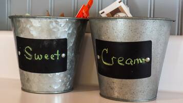 Due secchi metallici con le etichette 'Sweet' e 'Cream', e un'etichetta a lavagna, posati su una superficie.