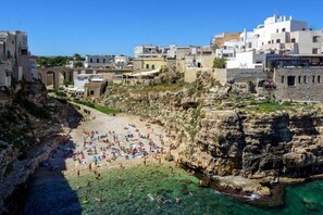 Une ville côtière dotée d’une plage rocheuse, d’eaux cristallines et de bâtiments à l’architecture méditerranéenne.