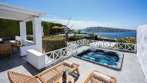 Una terraza en la azotea con jacuzzi, zona de estar y vistas al mar.