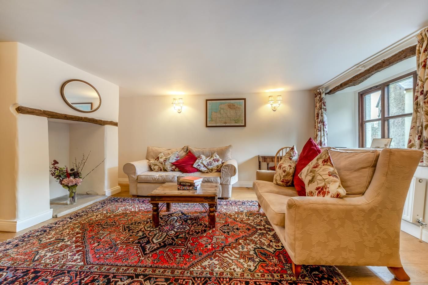 Un salon avec un tapis à motifs, deux canapés, une table basse et un tableau accroché au mur.