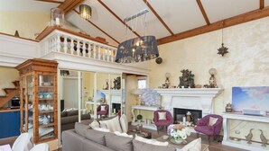 A spacious living room with a high ceiling, a fireplace, and a large window. - Winter Garden - NAVONA SQUARE (Roma)