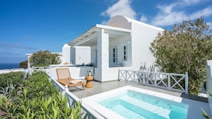 Een witte villa met een zwembad op het dak, terras en uitzicht op zee.
