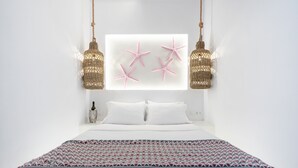 Een moderne slaapkamer met een groot bed, een decoratief wandkunstwerk en twee hanglampen.