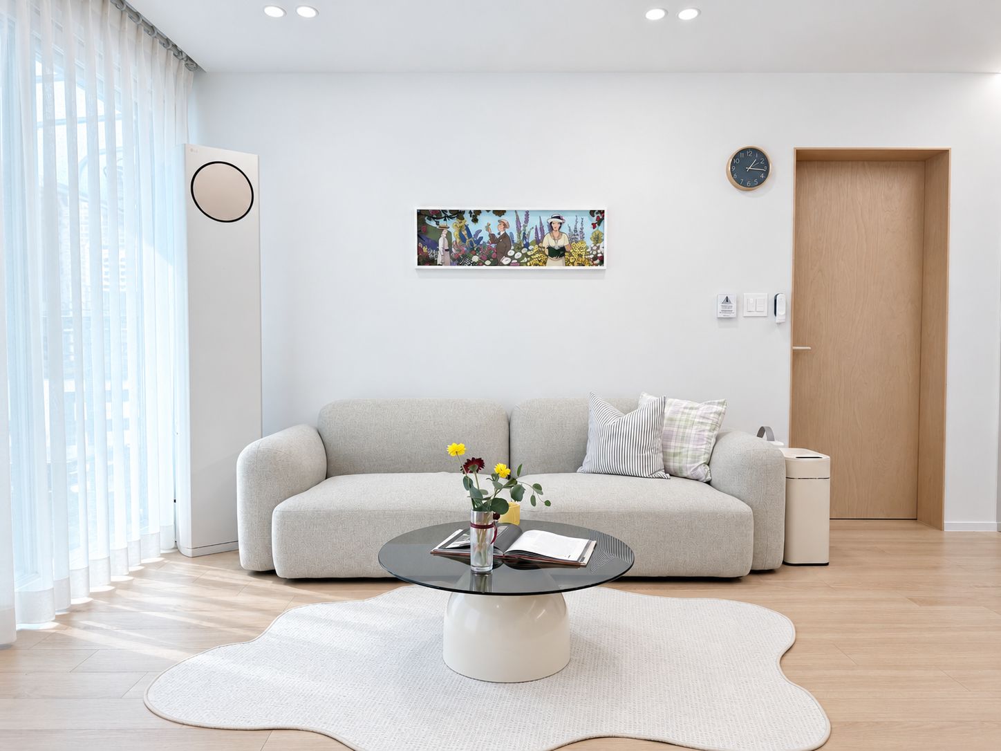 A modern living room with a sofa, a coffee table, and a painting on the wall.