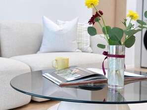 A glass table with a magazine, a yellow mug, and a vase with flowers. - 6Min Hongdae | 83㎡ Family House | Private Yard (서울)