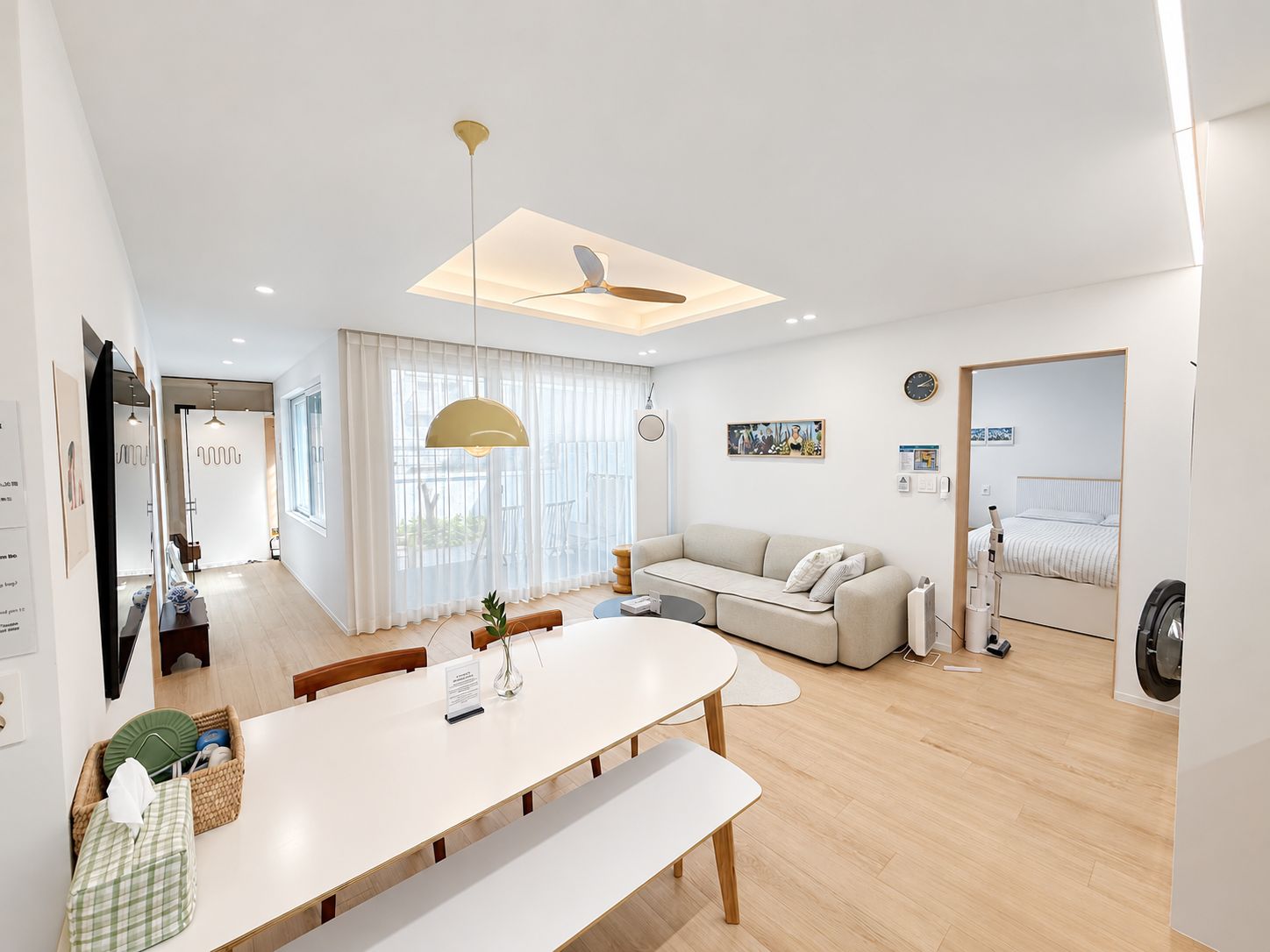 A modern living room with a sofa, dining table, and a ceiling fan.