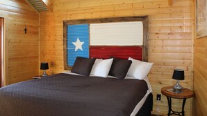 A wooden room with a bed, two bedside tables, and a window. - Beautiful Log cabin overlooking a meadow (Pipe Creek)