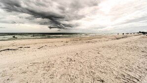 A beach with a wide sandy shore and a stormy sky. - Walk to Beach: Resort-Style Siesta Key Condo! (Siesta Key)
