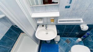 A bathroom with a white sink, a toilet, a blue shower, and a white bathtub. - Apartments Ivana (TR) -Studio with Terrace ( A2) (Trogir)