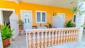 A patio with a white table and chairs, surrounded by potted plants and a beige balustrade. - Apartments Ivana (TR) -Studio with Terrace ( A2) (Trogir)