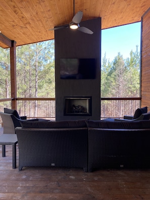 A covered outdoor seating area with wicker furniture, a ceiling fan, and a fireplace. - *Brand New* Sweet Pines Lodge: Modern Luxury nestled in on a private cul-de-sac  (Broken Bow)