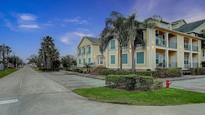 A multi-story residential building with balconies, a fire hydrant, and a clear sky. - Luxury vacation Kemah, TX condo. Bars and restaurants within walking distance. (Kemah)